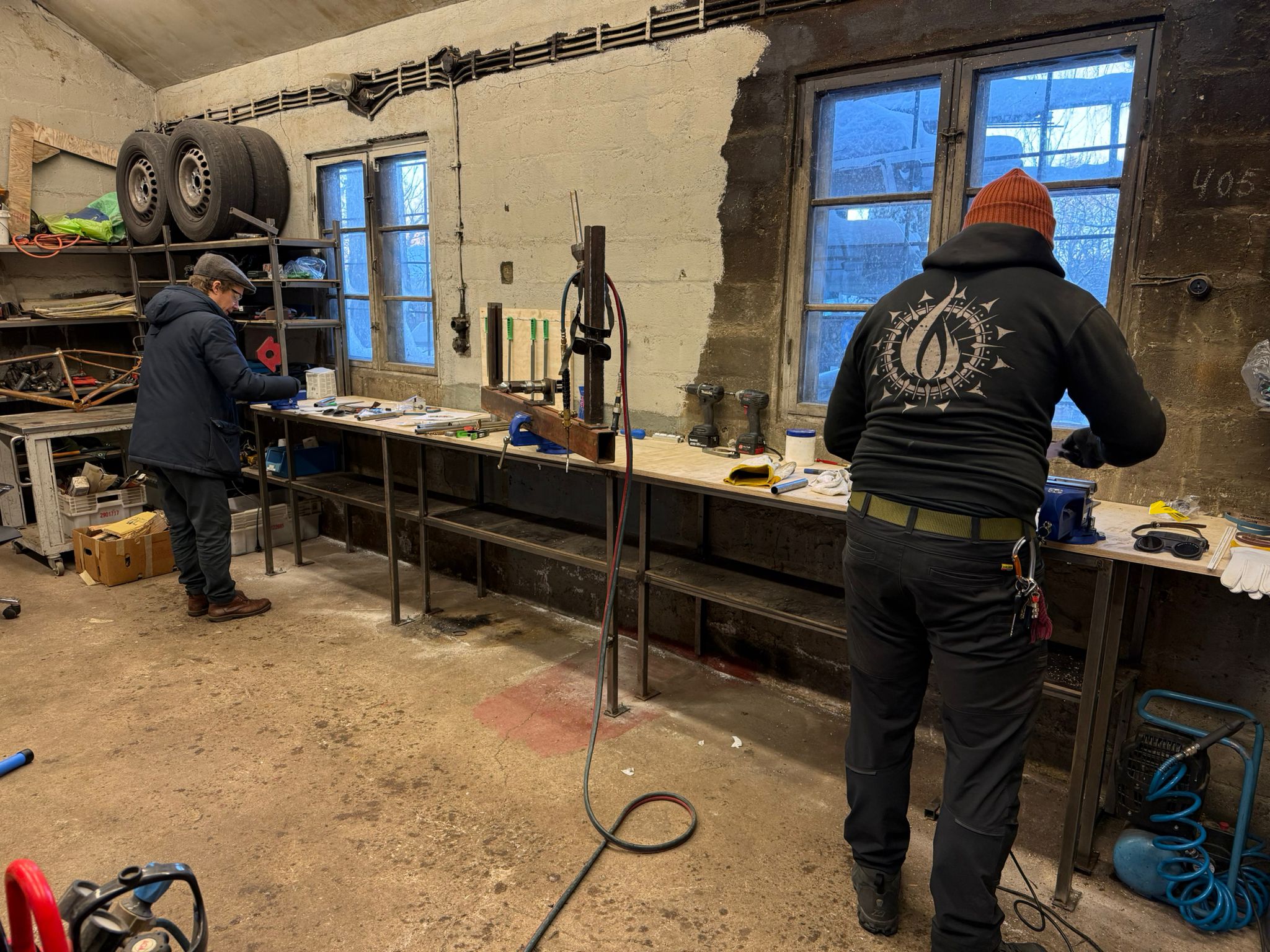 Kaksi henkilöä työskentelemässä polkupyöräpajassa